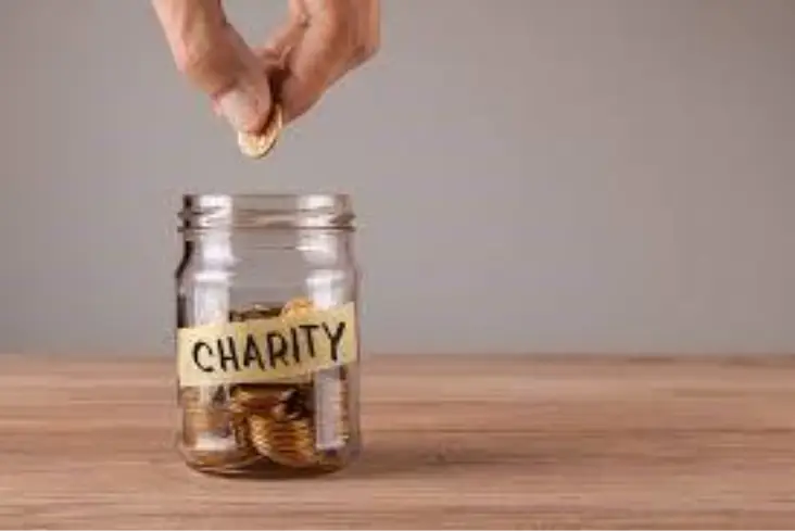 A glass jar being filled with coins, representing small acts of giving that accumulate into community support